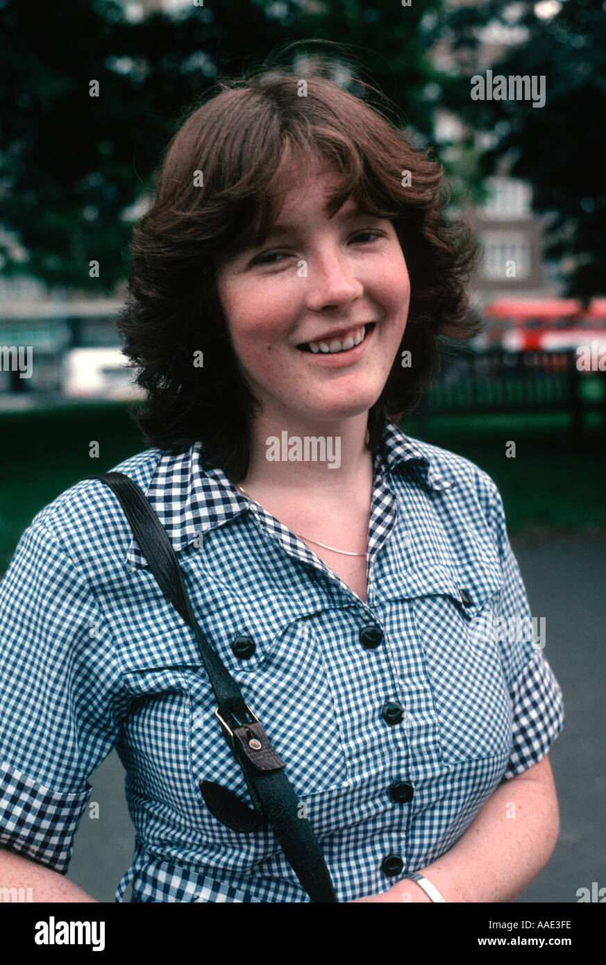 La donna degli anni settanta in una controllata blu vestito con un sorriso allegro e rosso scuro capelli Foto Stock
