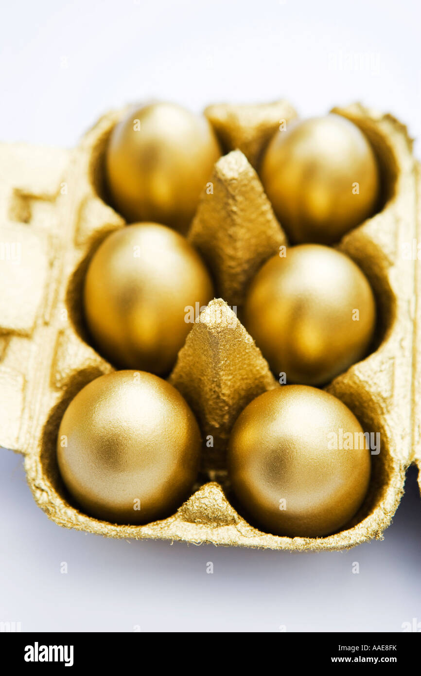 Golden uova in una scatola per uova su sfondo bianco Foto Stock