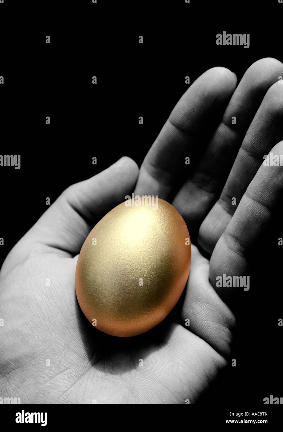 Un uovo dorato nel palmo di una mano Foto Stock