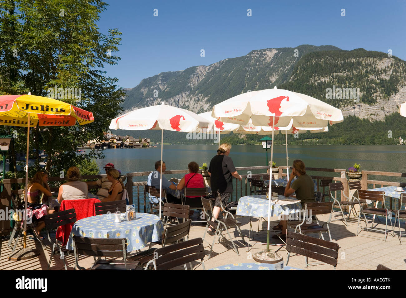 Gli ospiti seduti sulla terrazza di un caffè presso il lago Hallstatt Hallstatt Salzkammergut Austria Superiore Austria Foto Stock