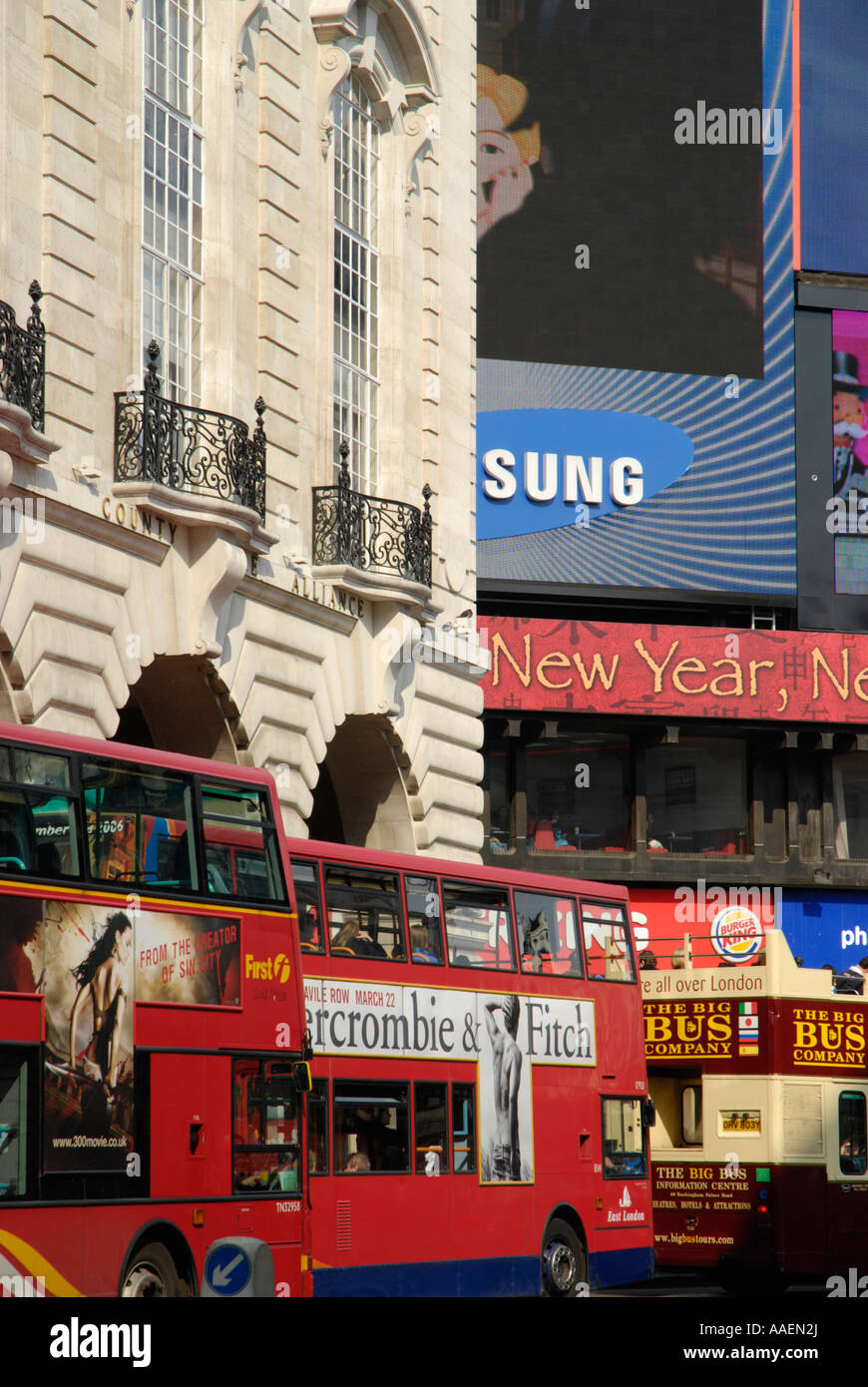 Gli autobus londinesi passando il famoso gigante di pubblicità al neon display in Piccadilly Circus London Inghilterra England Foto Stock