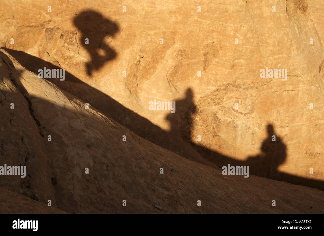 Ombre sulla roccia compresi saltando la figura presa sul percorso di scomposizione sul Jebel Khazali nel Wadi Rum Area protetta della Giordania Foto Stock