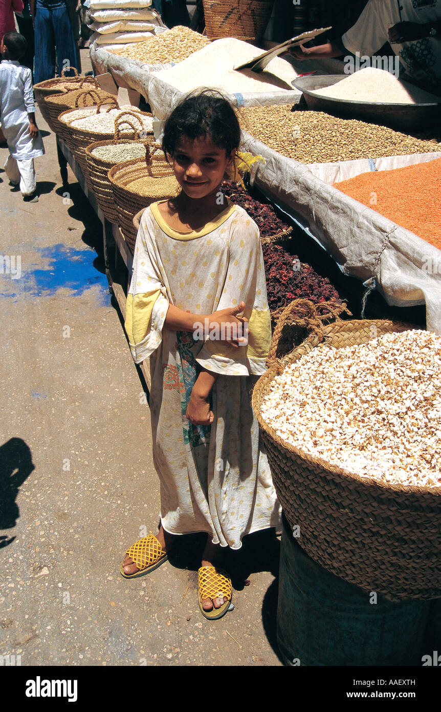 Piccola ragazza con ceste di grano e lenticchie al mercato Luxor Egitto Foto Stock
