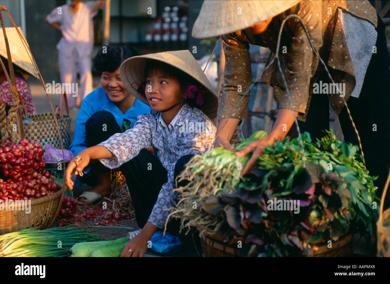 Una giovane ragazza vendere verdure a un mercato di strada ben tre nel delta del Mekong Vietnam Foto Stock