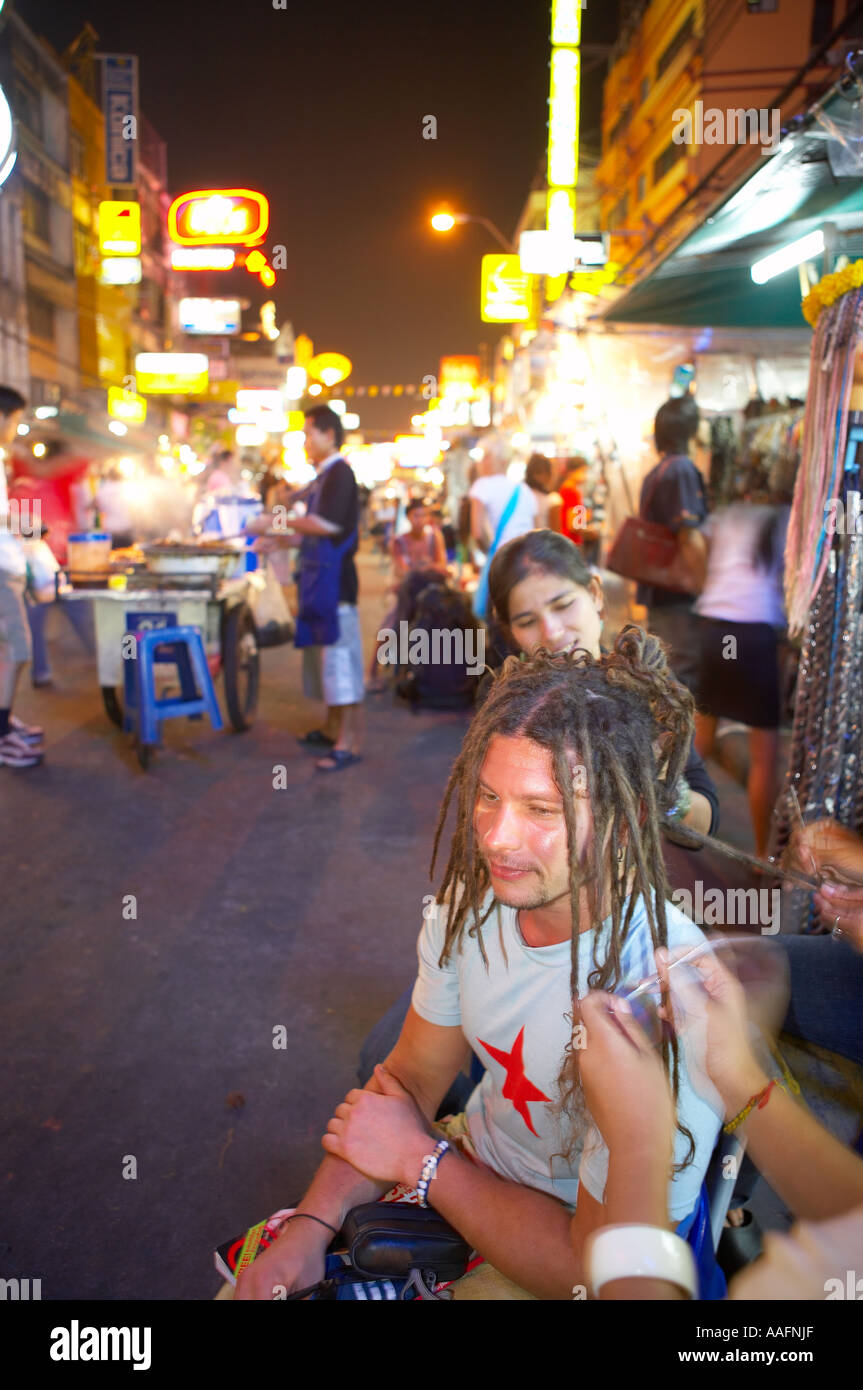 Backpacker avente i suoi capelli cromato in Khao San Road di Bangkok in Thailandia Foto Stock