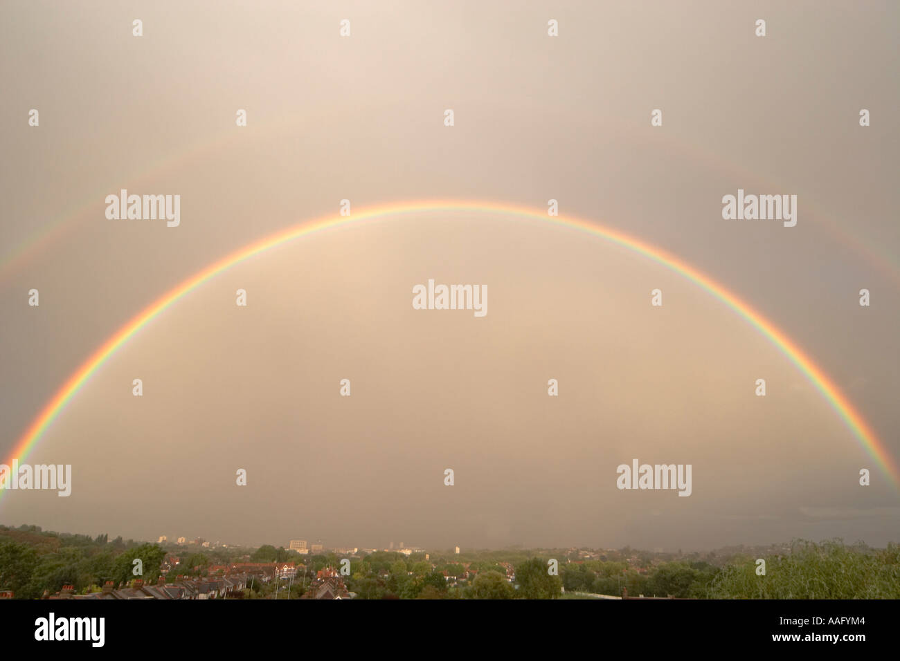 Serata drammatica doppio arcobaleno nel cielo grigio al di sopra dei tetti di suburbana nei sobborghi di Muswell Hill Londra N10 Inghilterra Foto Stock