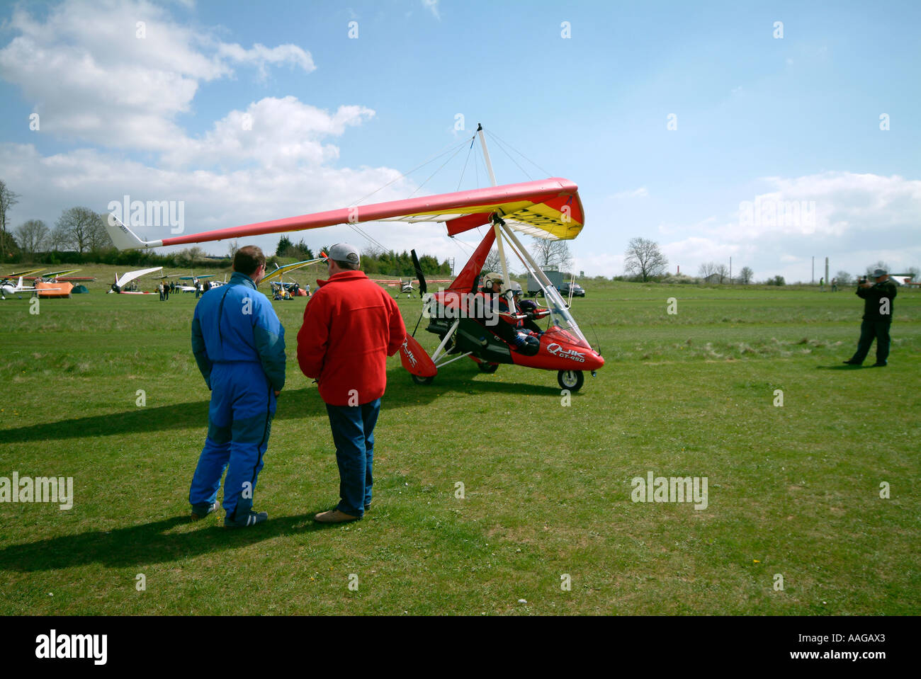 Gli astanti guardare come un Flexwing taxi di decollare dal Popham Airfield Foto Stock
