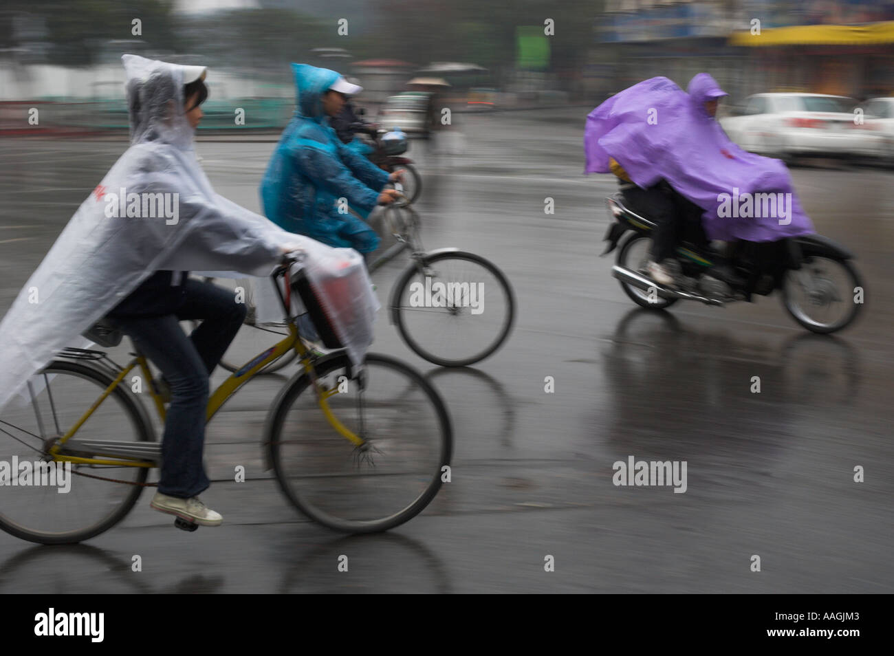 Vietnam Hanoi il vecchio quartiere di persone a cavallo su 2 ruote in condizioni di bagnato con protezione in nylon Foto Stock
