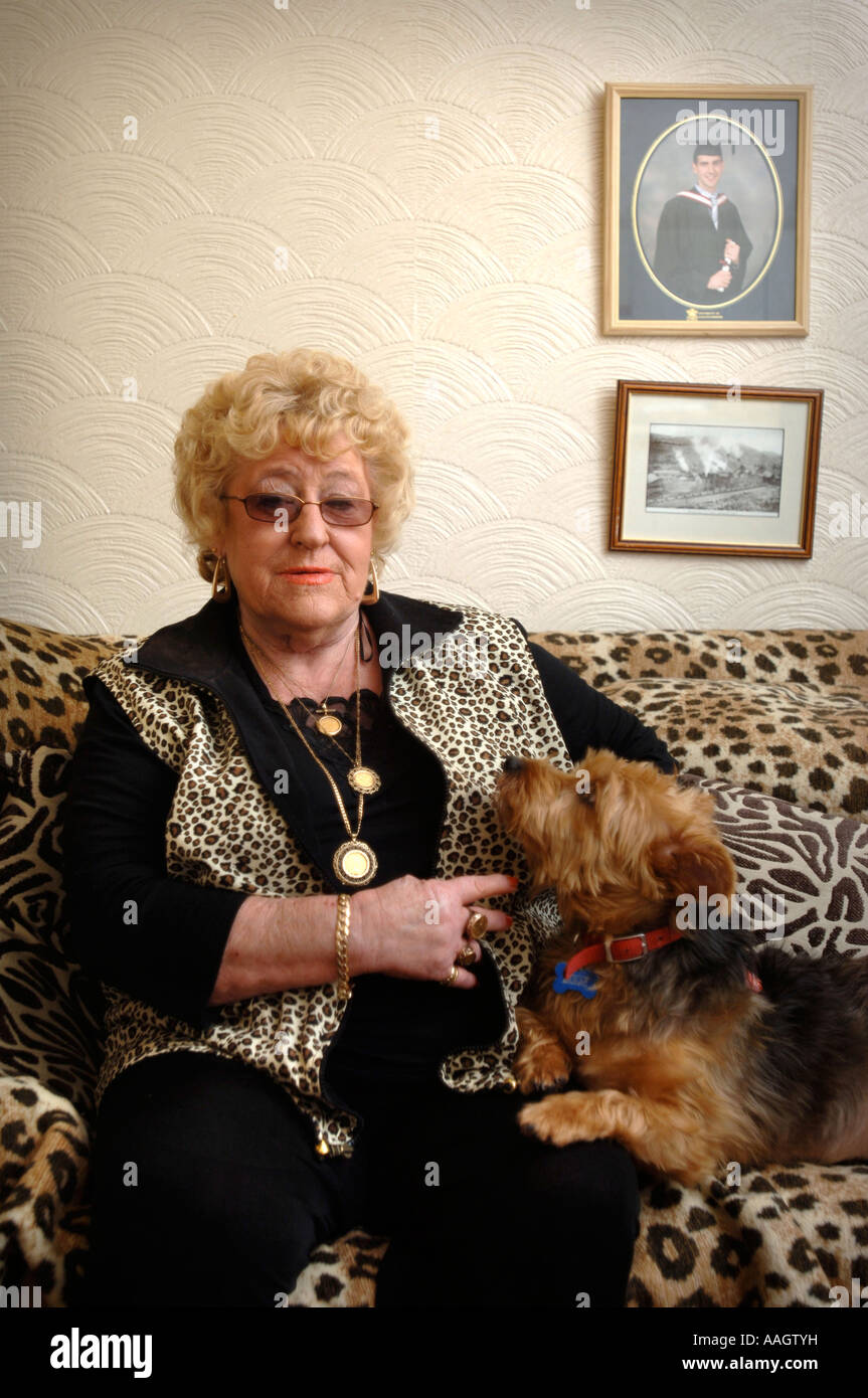 Una femmina di titolare di pensione o di rendita con una pelle di leopardo divano e gilet Wales UK Foto Stock