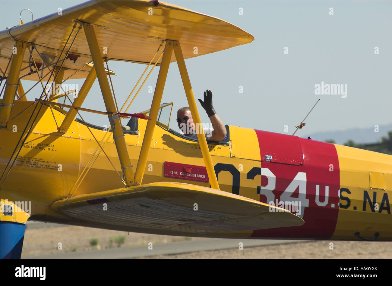 Un rullaggio Stearman biplano con ondulazione pilota Foto Stock