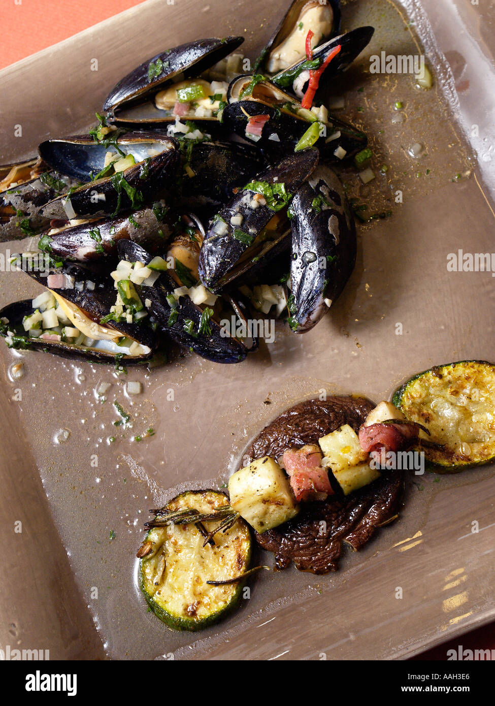 Cucina Fusion moderno e alla moda e cozze piatto su una piastra quadrata Foto Stock