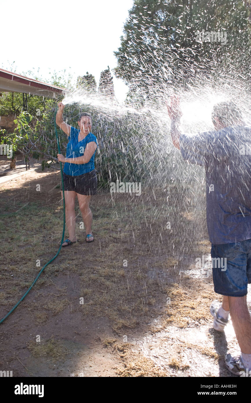 Acqua lotta in un giardino, coppia giovane Foto Stock