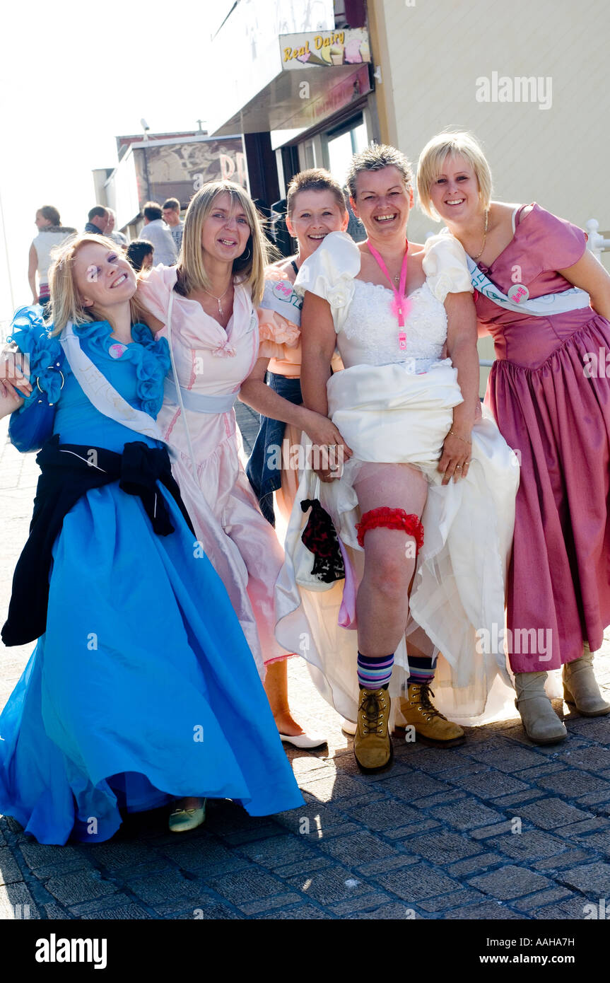 Il gruppo di cinque 5 donne sulla parte di gallina aberystwyth promenade vestito di vecchi abiti a sfera dal negozio di carità, mostrando garter sulla coscia REGNO UNITO Foto Stock