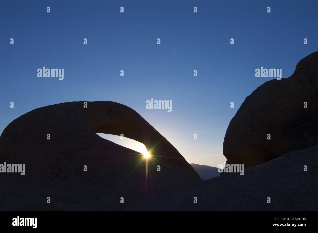 Sun proveniente attraverso arco nella roccia a alabama hills recreation area eastern sierra nevada california usa Foto Stock