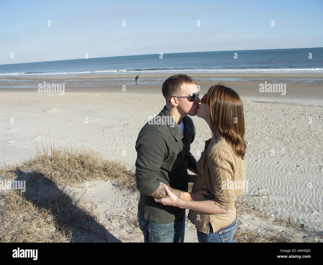 Sposi novelli baciare sulla spiaggia Foto Stock