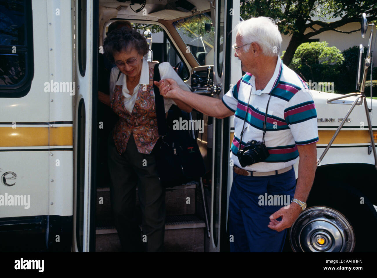 Caring marito contribuisce aiutando protegge la moglie donna Senior in arrivo arrivo lasciando van. Attivo lo stile di vita di pensionamento attività touring turisti viaggiano Foto Stock