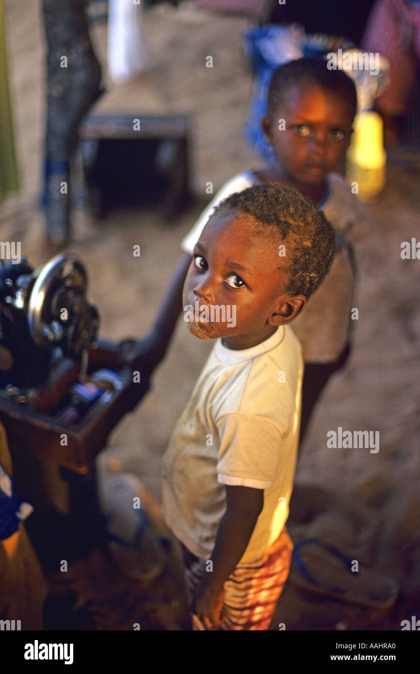 I bambini del Gambia in piedi dalla macchina da cucire in Banjul Gambia Africa Occidentale JMH0672 Foto Stock