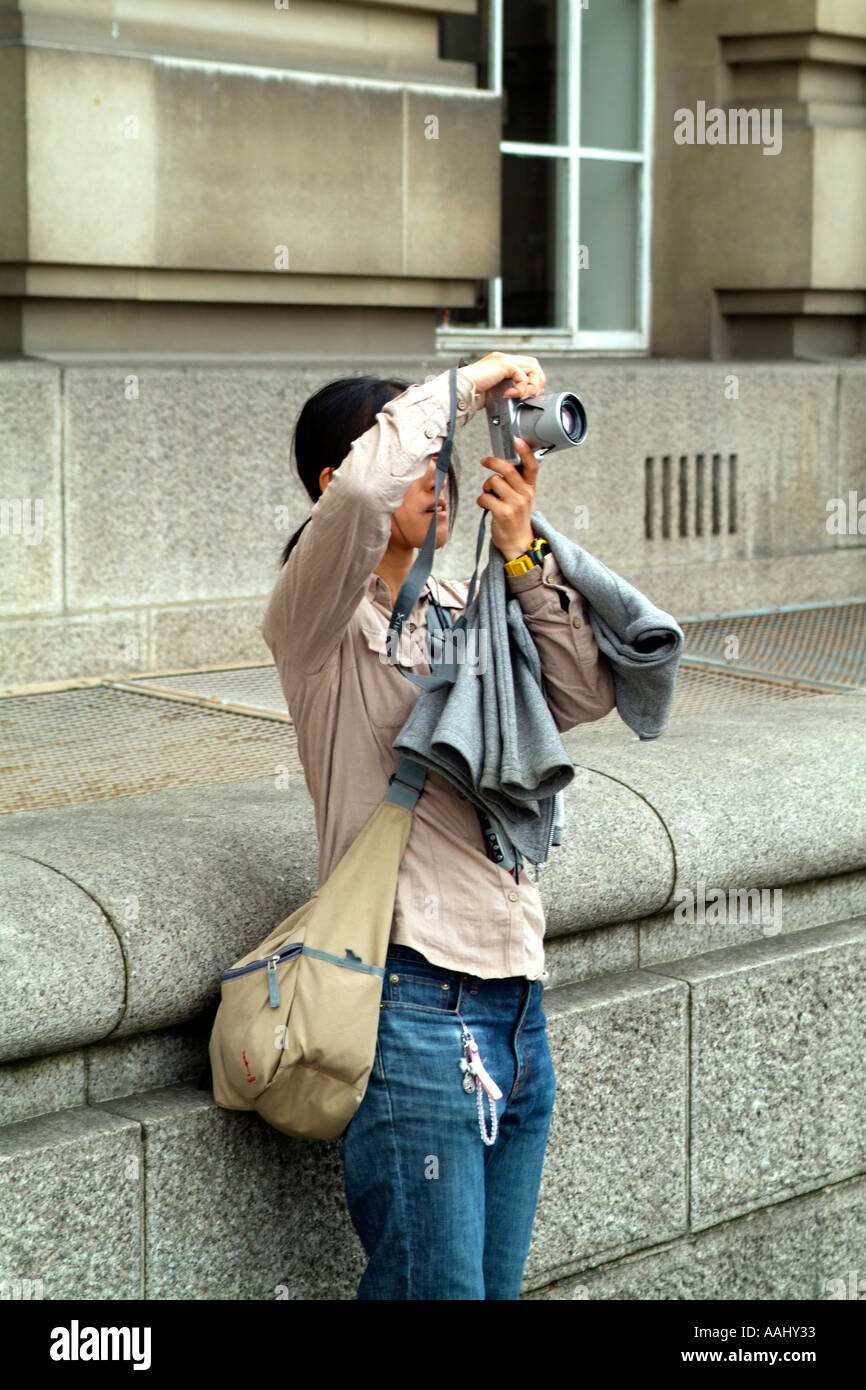 Femmina asiatica turistica prendendo una foto digitale a Londra. Foto Stock