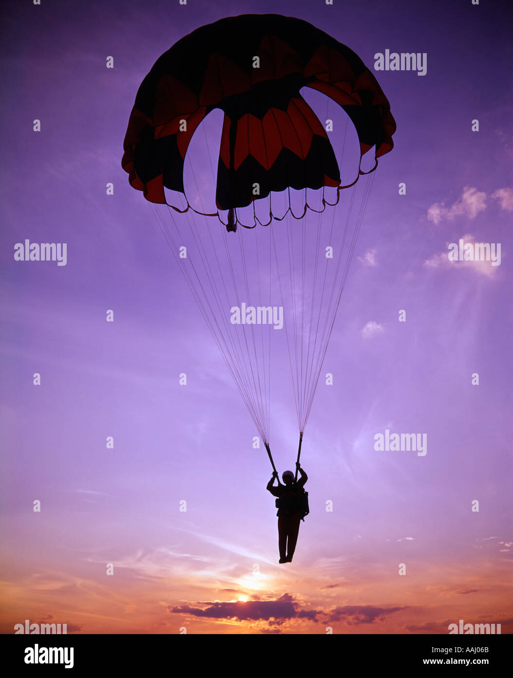 Paracadutista paracadute di atterraggio al tramonto Foto Stock