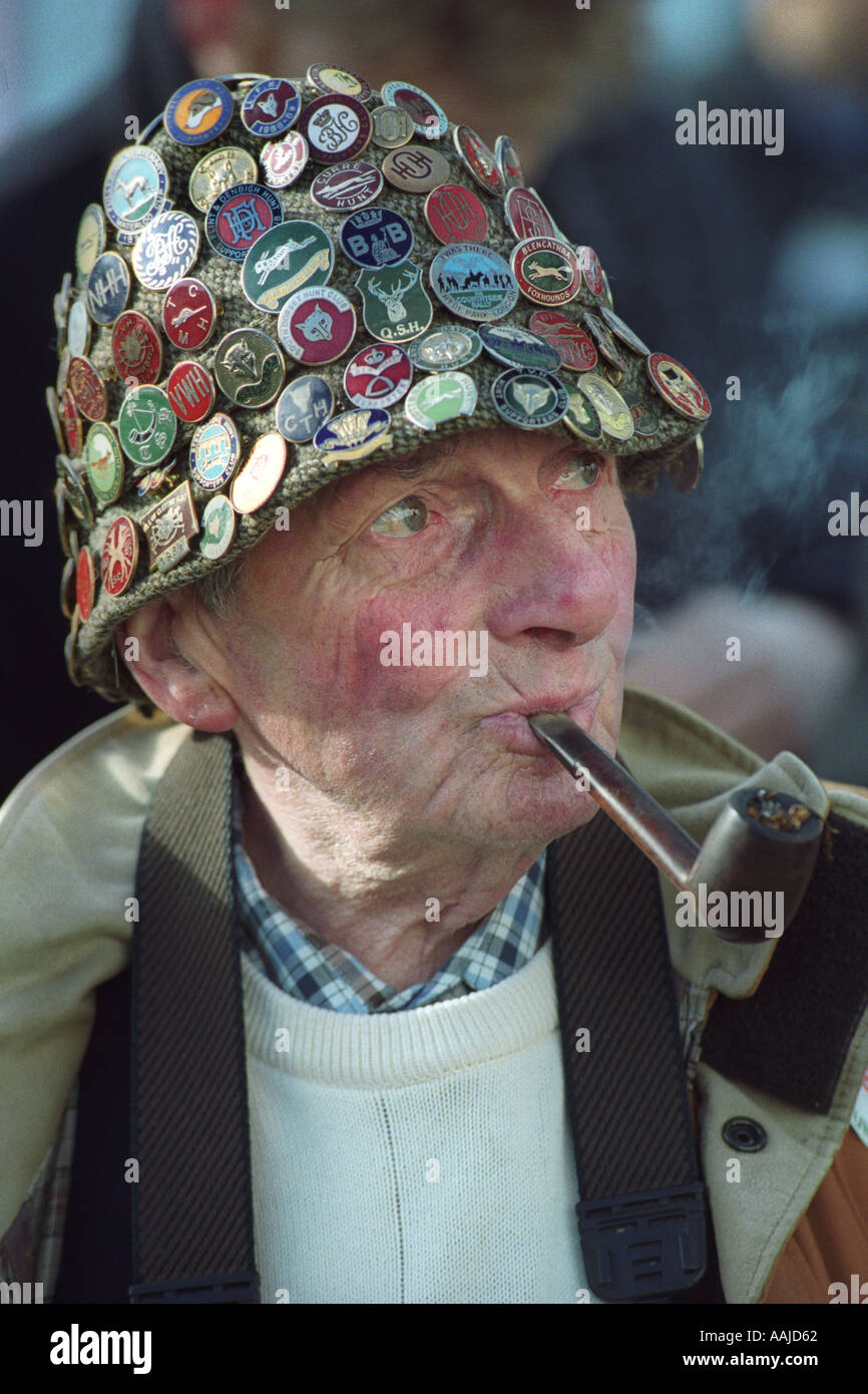 Senior uomo tubazione di fumare con il cappello pieno di distintivi al  rally a sostegno della caccia alla volpe a Coopers campo Cardiff South  Wales UK Foto stock - Alamy