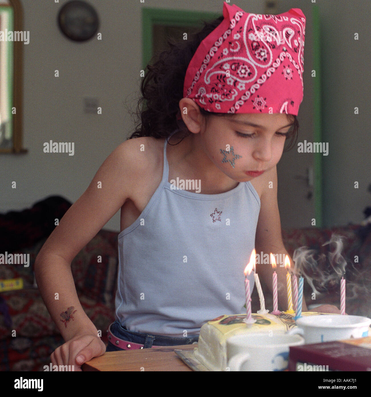 Una ragazza si brucia le candele sulla sua torta di compleanno per il suo sesto compleanno a casa di Londra, Regno Unito. Foto Stock