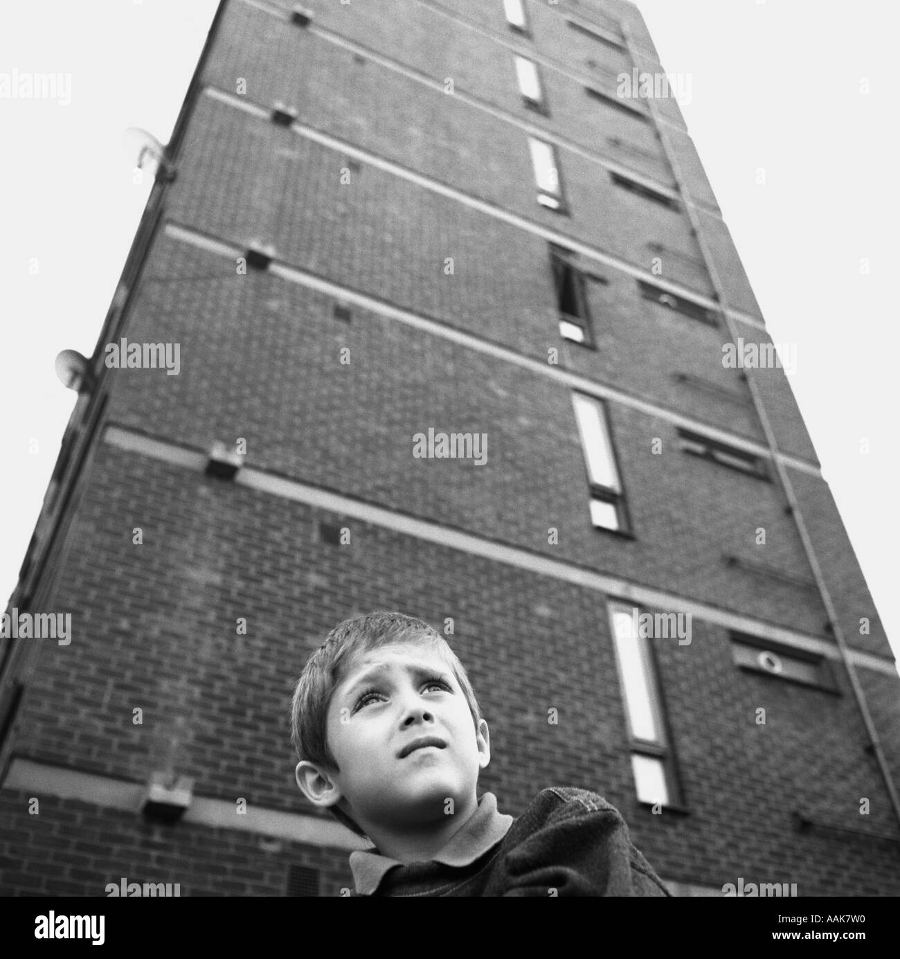 Un ragazzo al di sotto di un blocco a torre di alloggi sociali, Clapton, Hackney, Londra, Regno Unito. Foto Stock