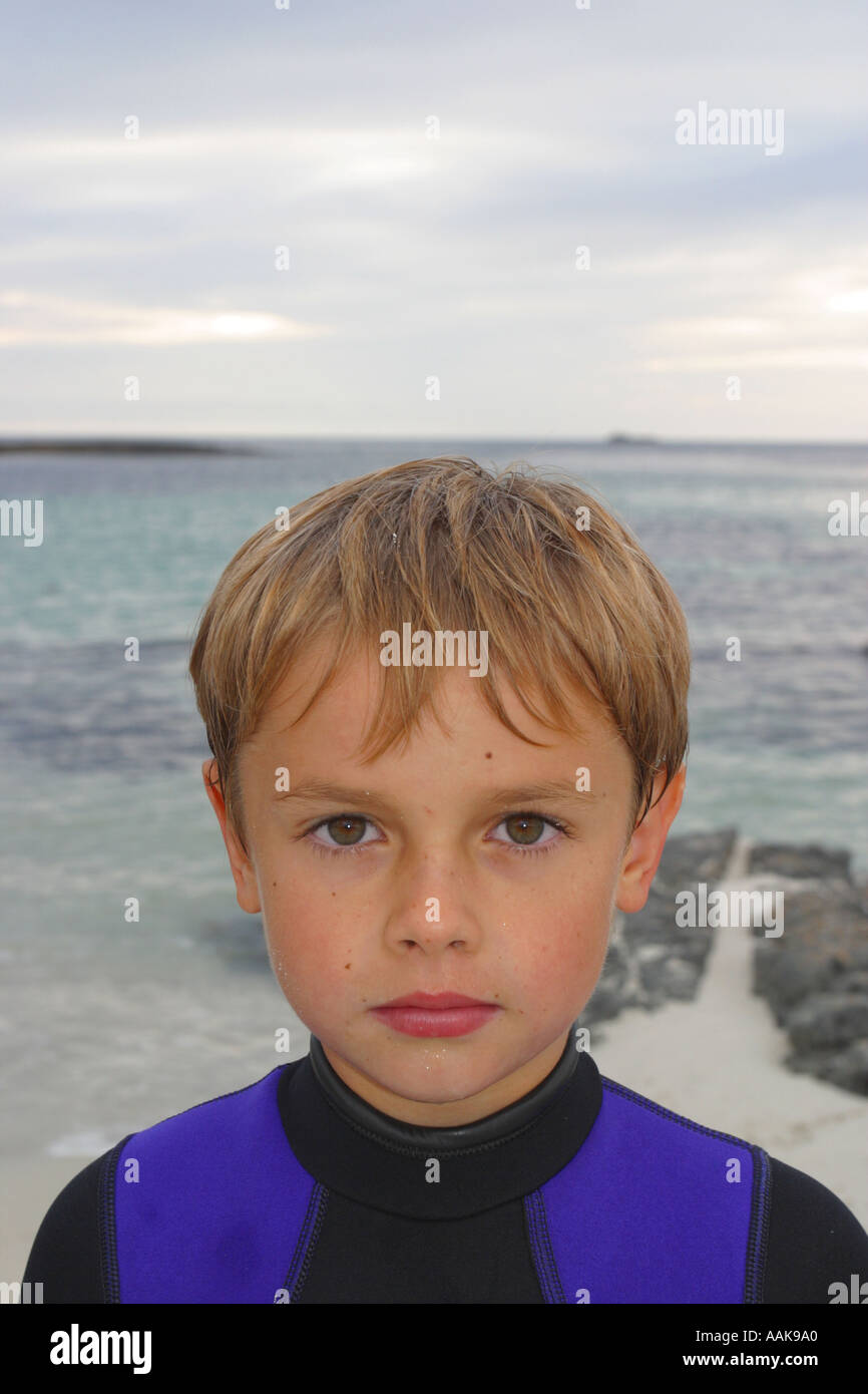Giovane ragazzo in testa e spalle indossando una muta su una spiaggia scozzese Foto Stock