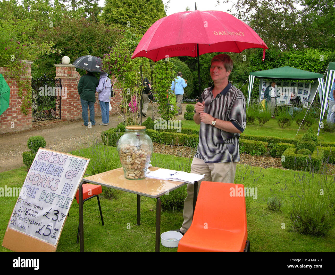 Uomo in piedi sotto la pioggia presso il village fete Foto Stock