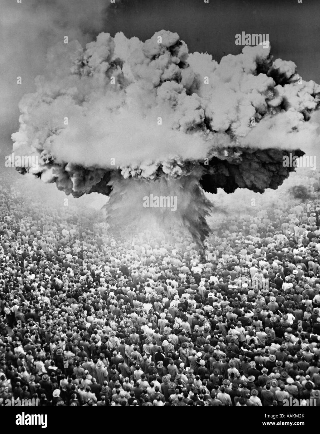 Anni Cinquanta anni sessanta la bomba atomica simbolica fungo MONTAGE nube su una grande folla di persone che guardano verso l'ESPLOSIONE Foto Stock