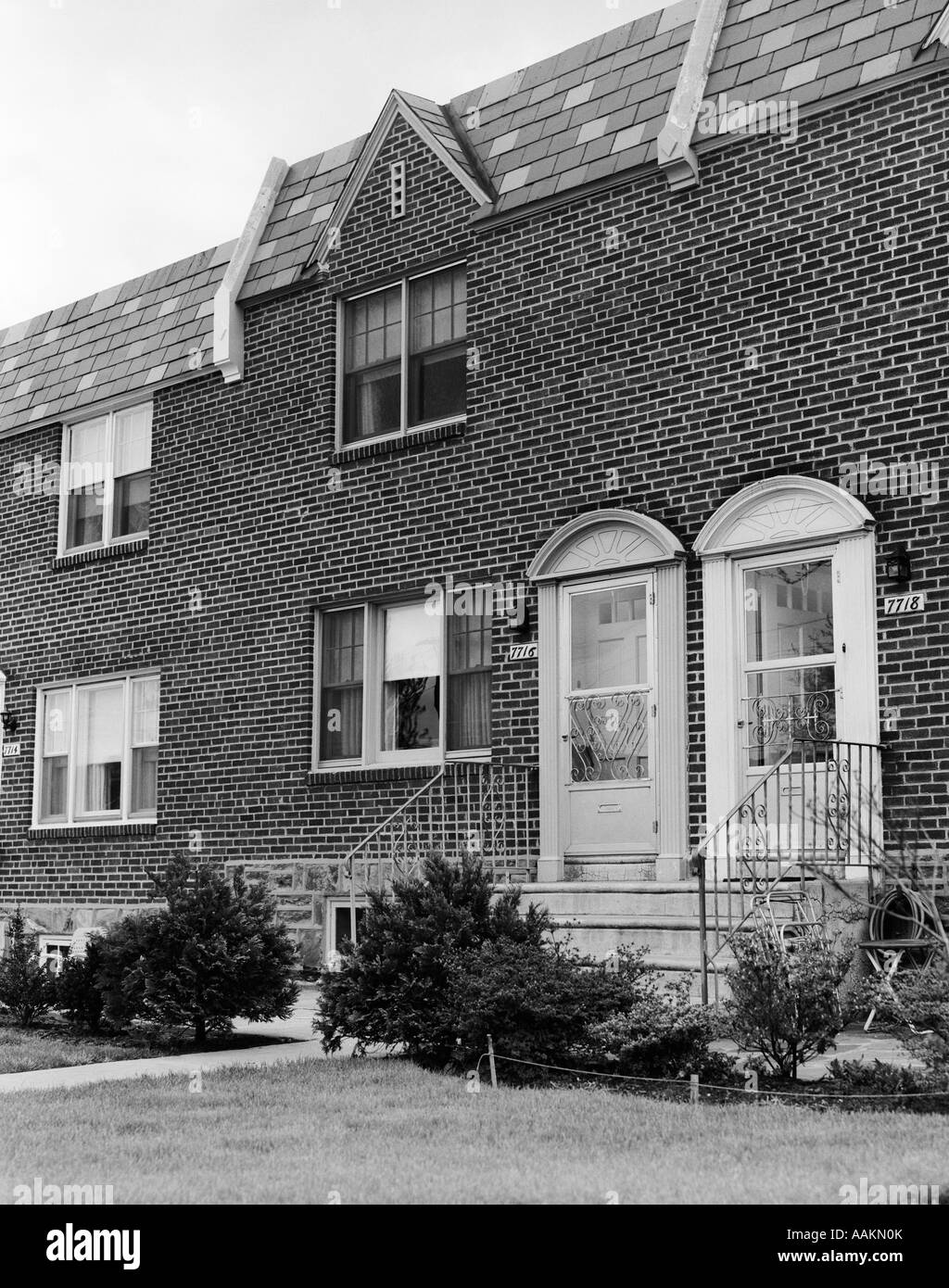 Anni Cinquanta due sportelli anteriori di attaccato mattone case a schiera con ANTERIORE STOOP SCALE Foto Stock