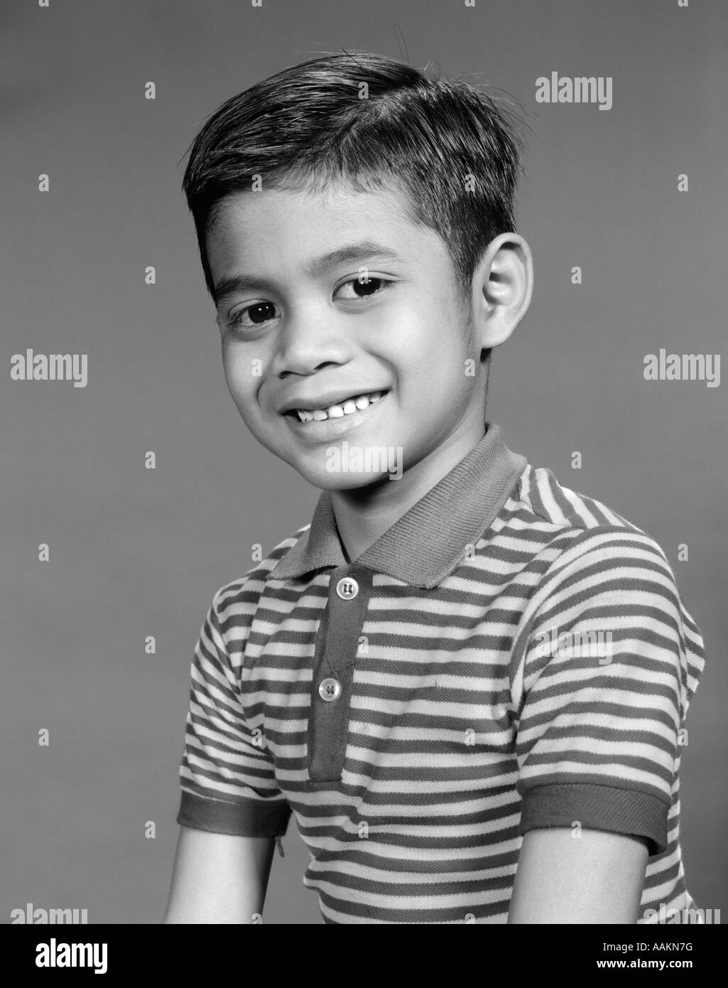 Anni Cinquanta anni sessanta ritratto sorridente ragazzo etnico indiano indonesiano asiatici IN STRIPED TEE SHIRT Foto Stock