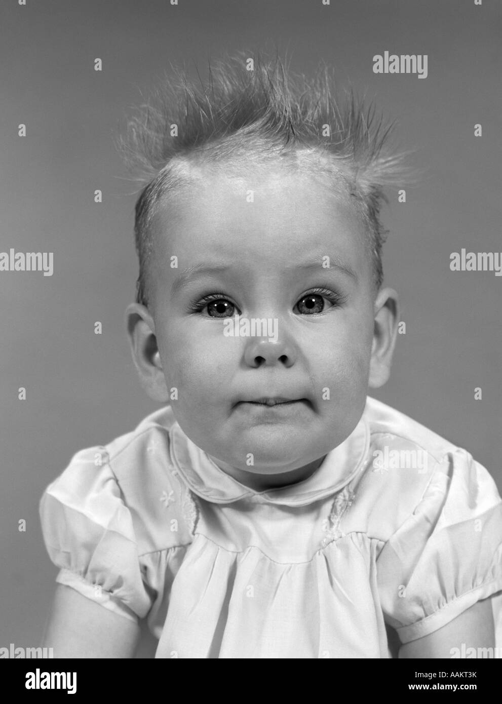 Anni sessanta testa sul ritratto DI BAMBINA IN ABITO increspato sempre dritti fino a capelli guardando la fotocamera Foto Stock