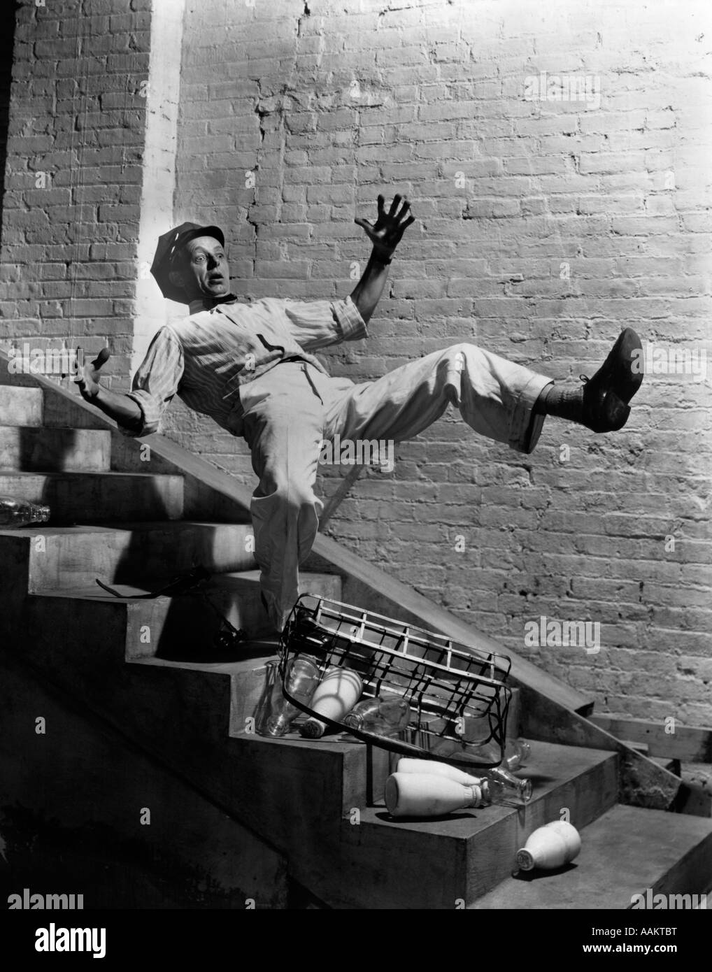 1940s lattaio cadere giù per le scale la caduta di bottiglie di latte Foto Stock