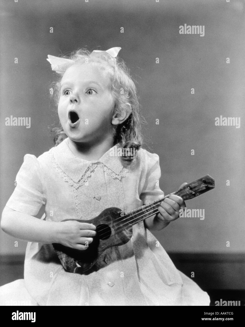 1930 bambina cantare e suonare un ukulele Foto Stock