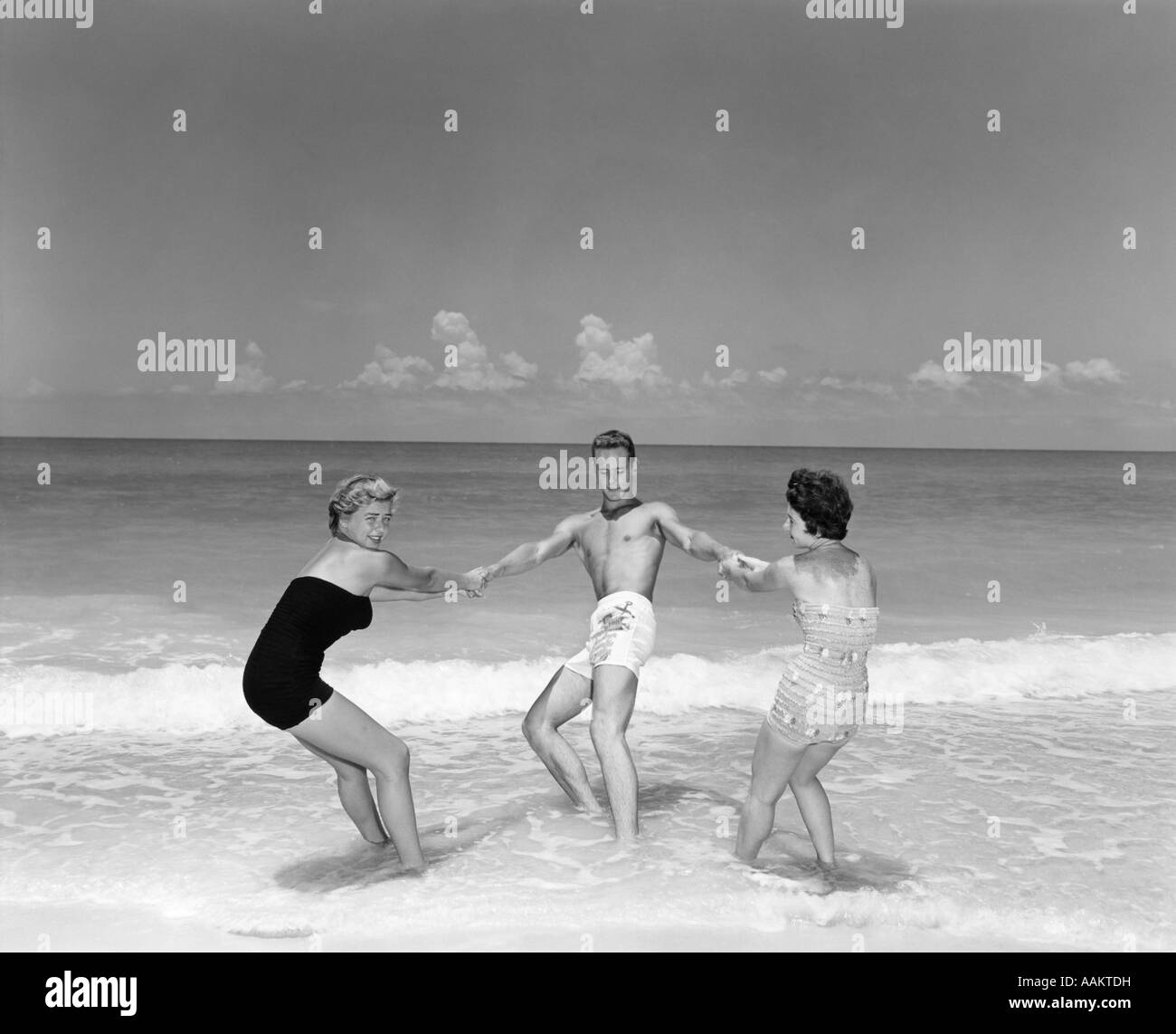 Anni Cinquanta uomini e due donne scorazzare nel BEACH SURF Foto Stock
