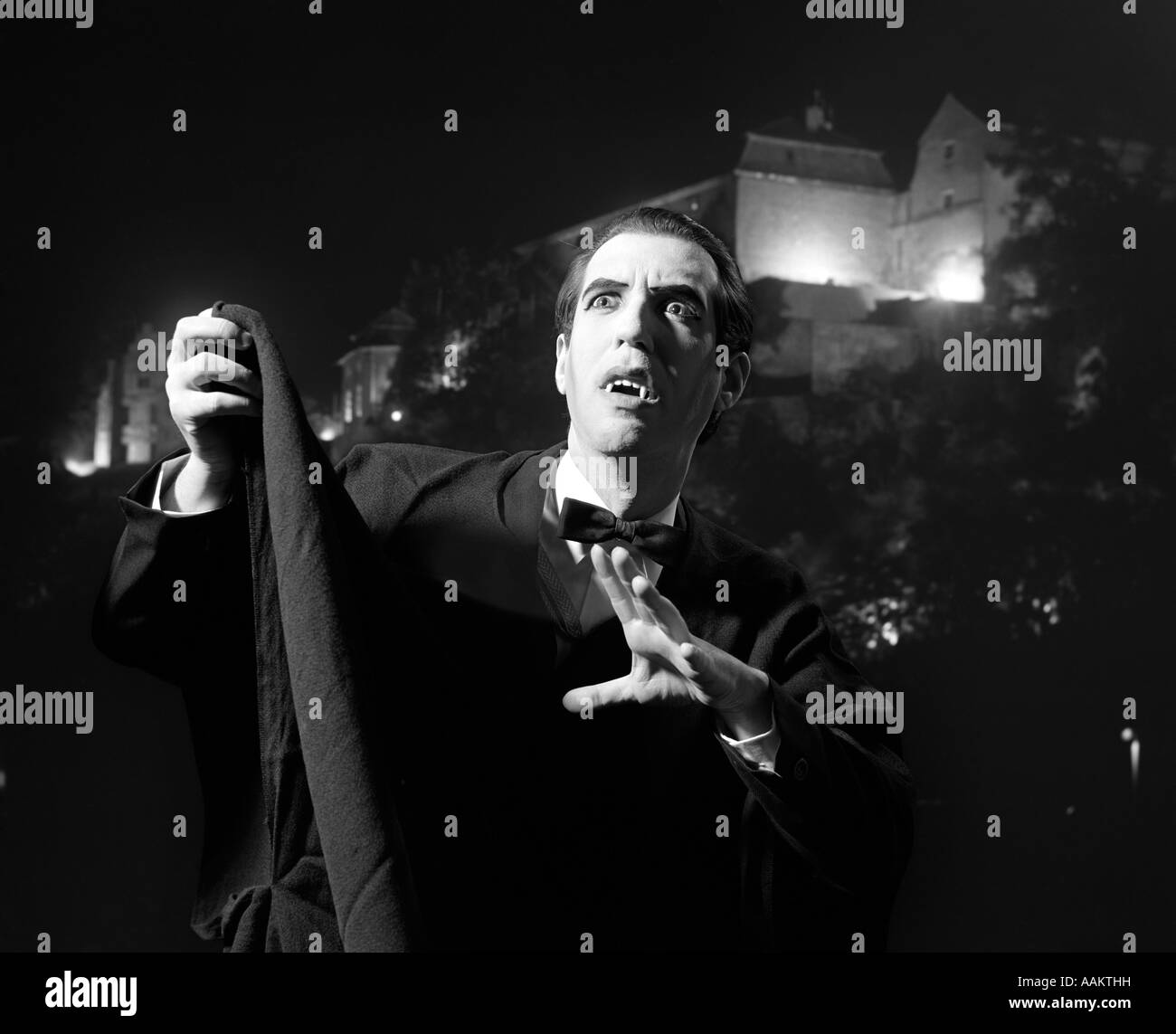 Anni Settanta HALLOWEEN Ritratto notturno di uomo che indossa il capo e zanne vestito come Dracula il vampiro Foto Stock