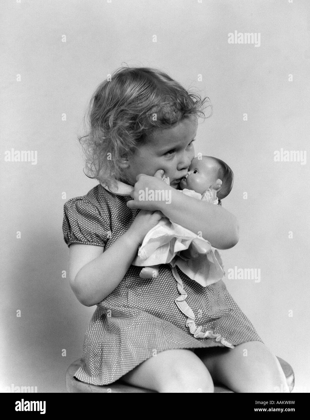 1930s grave TODDLER triste ragazza baciare BABY DOLL Foto Stock