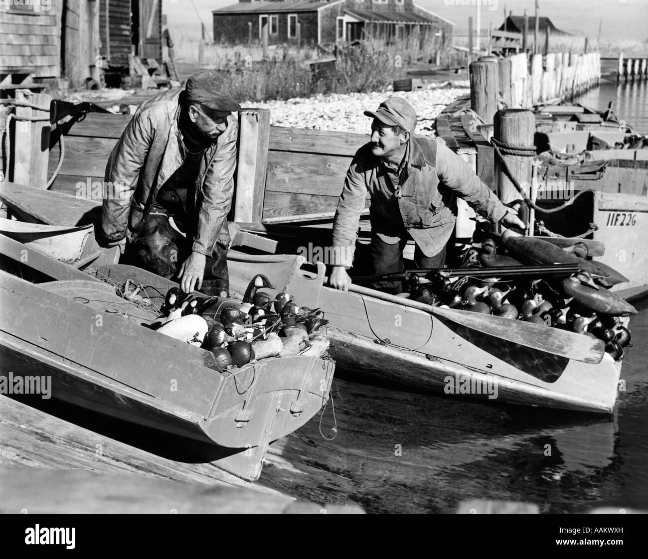 Trenta anni quaranta due uomini cacciatori di anatre CARICAMENTO SNEAK-BOX BARCHE CON IL CANADA GOOSE DECOY e fucili BARNEGAT BAY NEW JERSEY USA Foto Stock