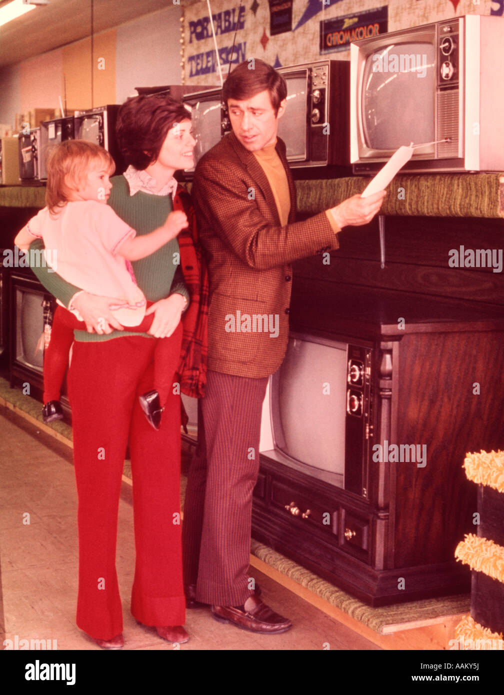 Anni sessanta anni settanta famiglia GUARDANDO IL PREZZO DEL TELEVISORE IN APPLIANCE STORE Foto Stock
