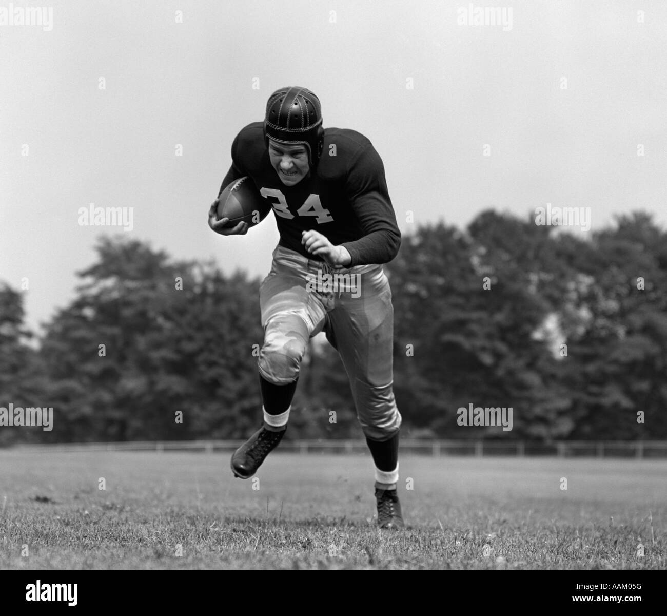 1940s FOOTBALL PLAYER IN ESECUZIONE CON LA PALLA VERSO LA TELECAMERA Foto Stock