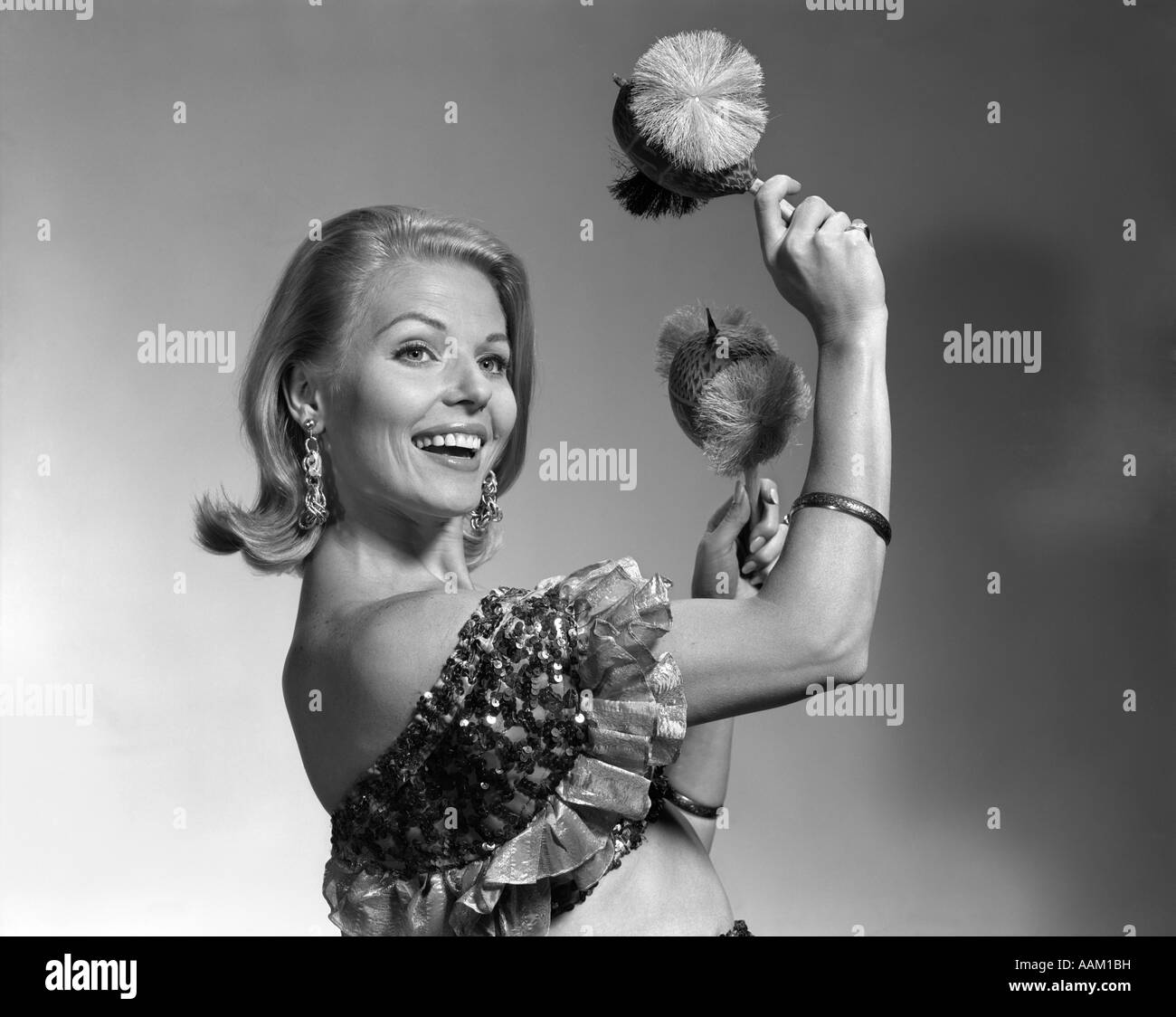 Anni sessanta sorridente DONNA BIONDA guardando le vibrazioni della fotocamera di rumore nelle sue mani usura increspato HALTER TOP Foto Stock