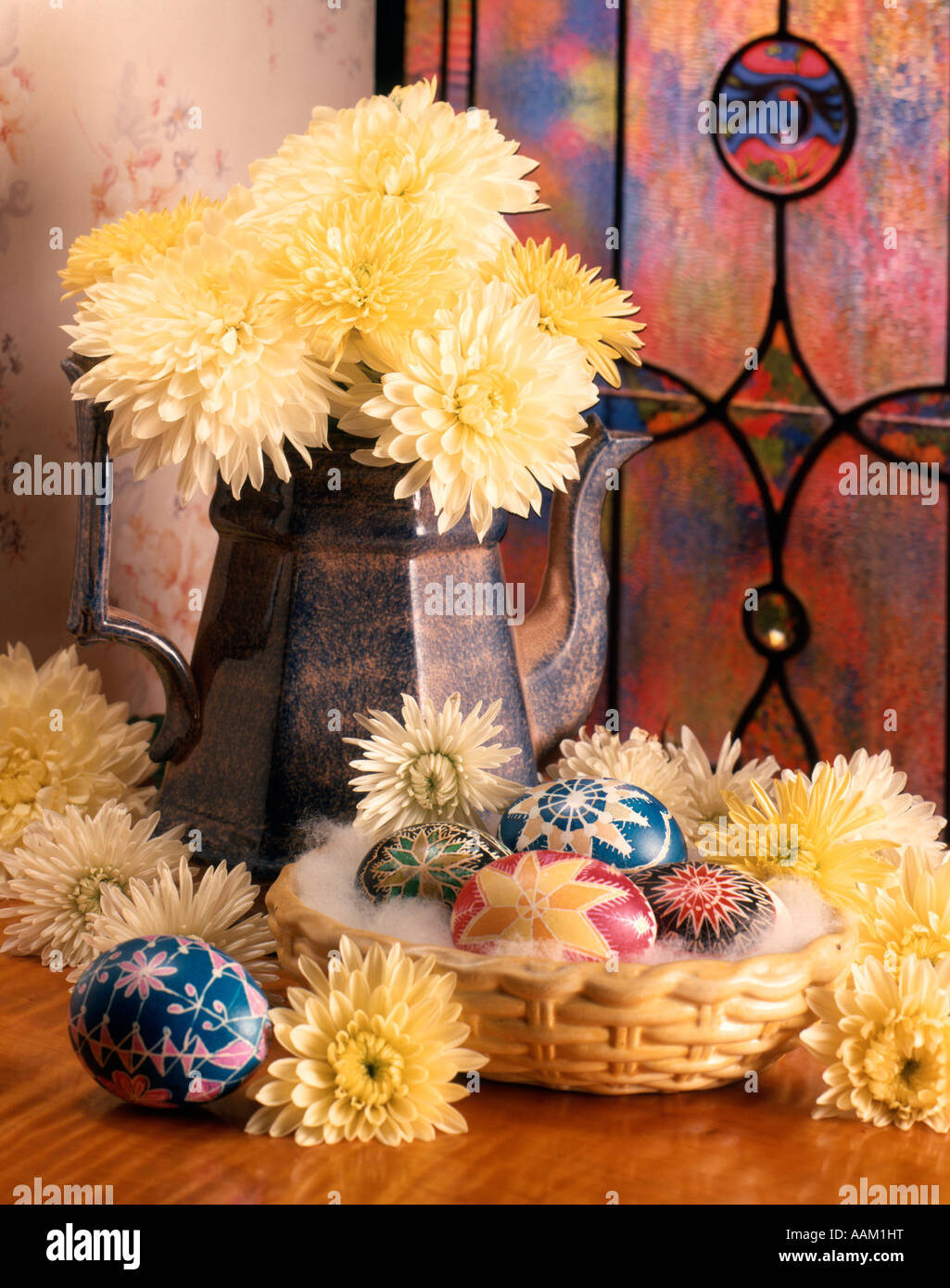 Pasqua ancora vita caffè in ceramica pentola piena di fiori gialli Piccolo cesto pieno di uova decorate vetrate a piombo Foto Stock