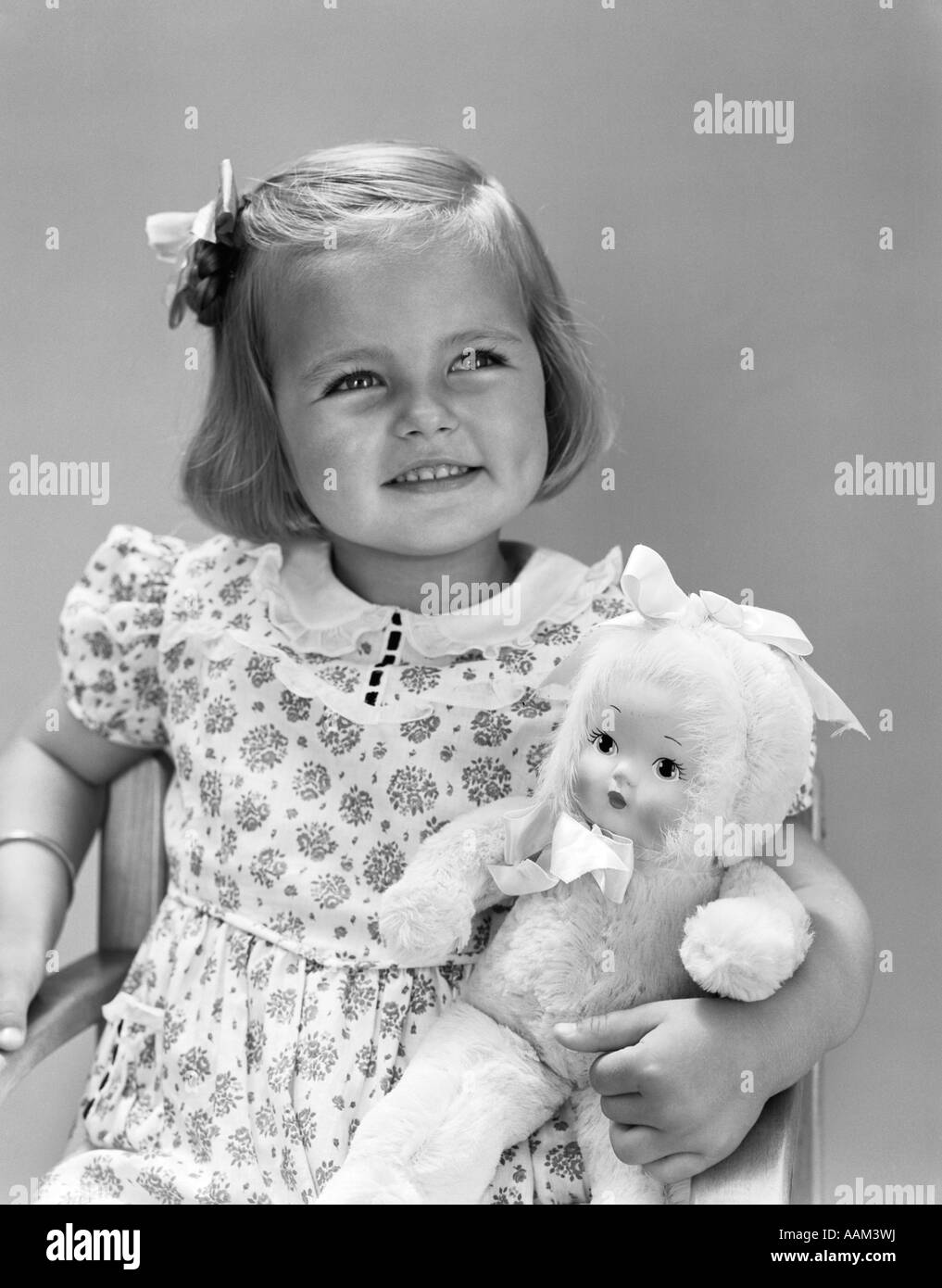 1930s 1940 BIONDA sorridente ragazza TODDLER HOLDING BAMBOLA GIOCATTOLO Foto Stock