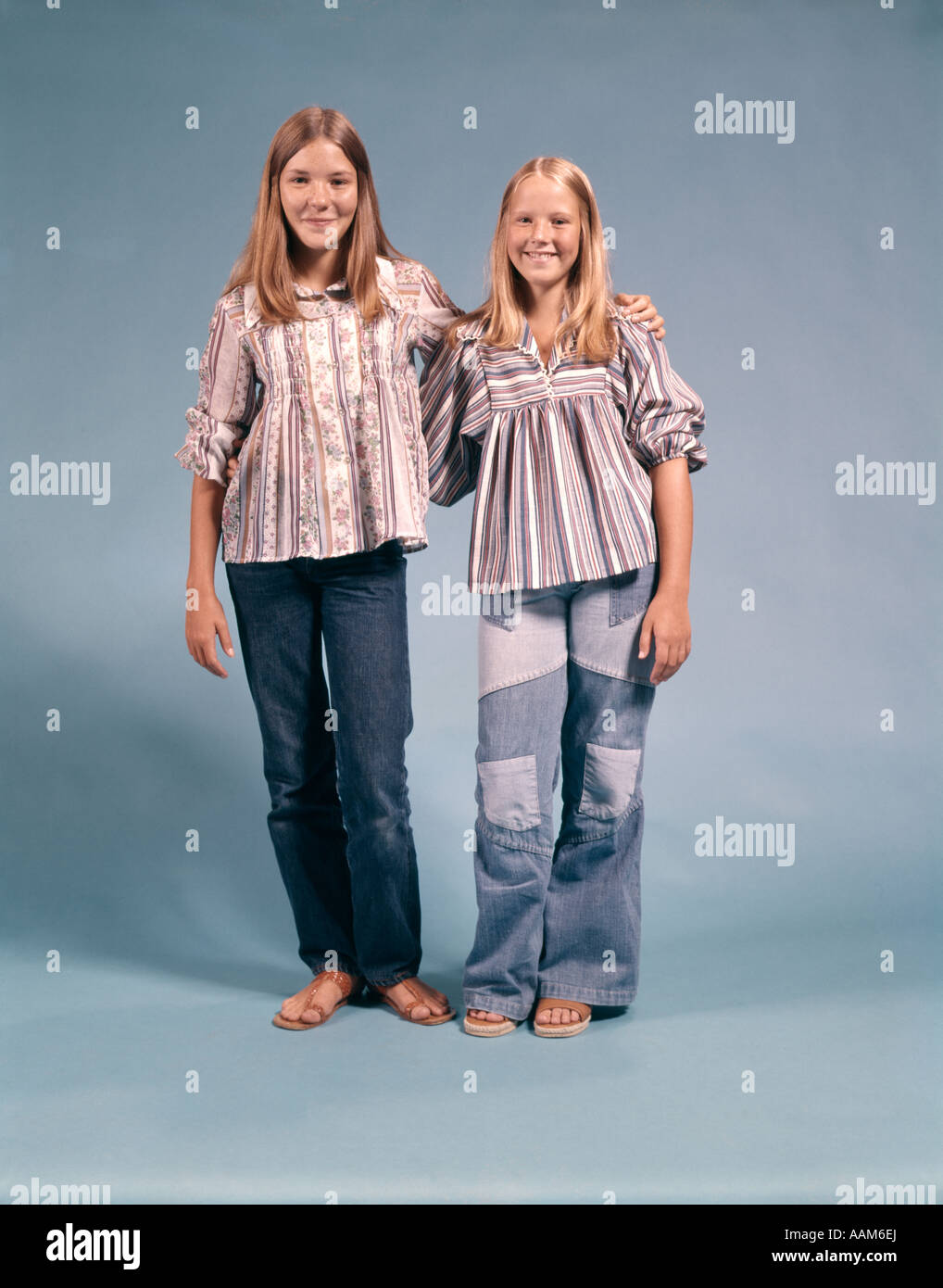 Due ragazze adolescenti in 1970 anni settanta abbigliamento bracci permanente intorno a ogni altro sorridente Foto Stock