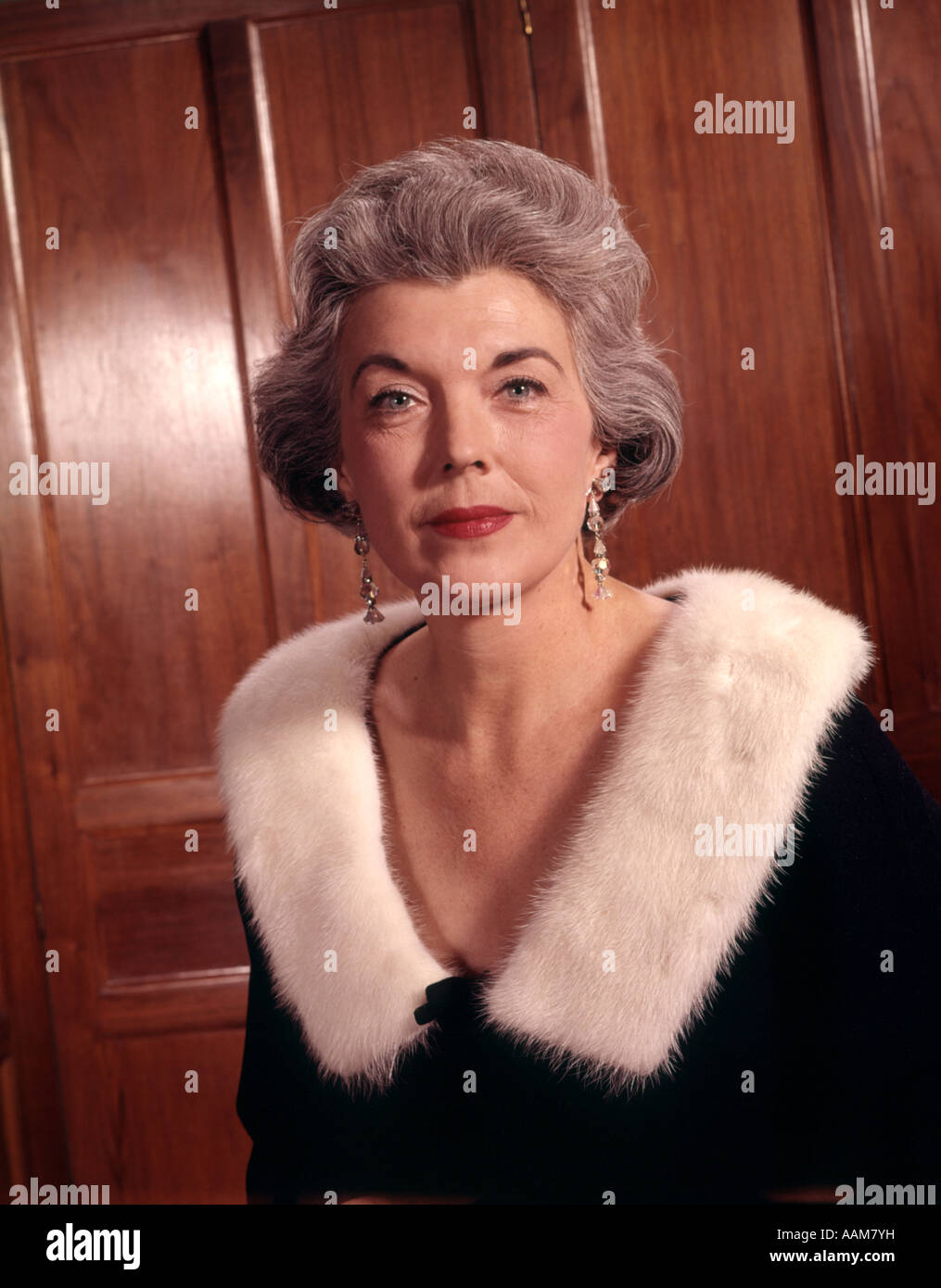 1960 anni sessanta senior eleganti donna anziana capelli argento formale maglione nero bianco ermellino pelliccia collare orecchini Foto Stock