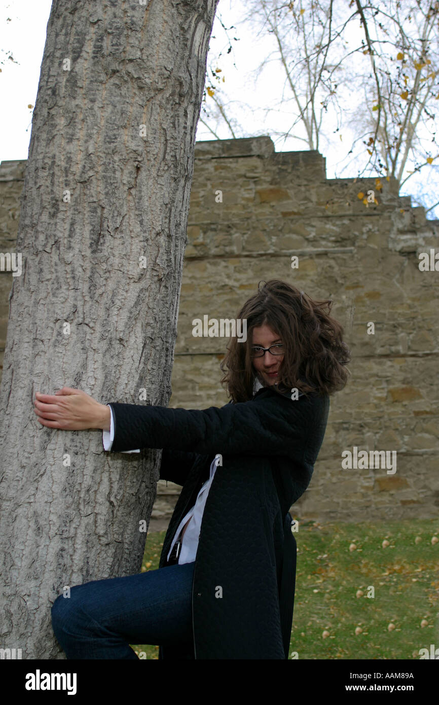 Verticale bruna caucasica modello femminile abbracciando un albero Foto Stock