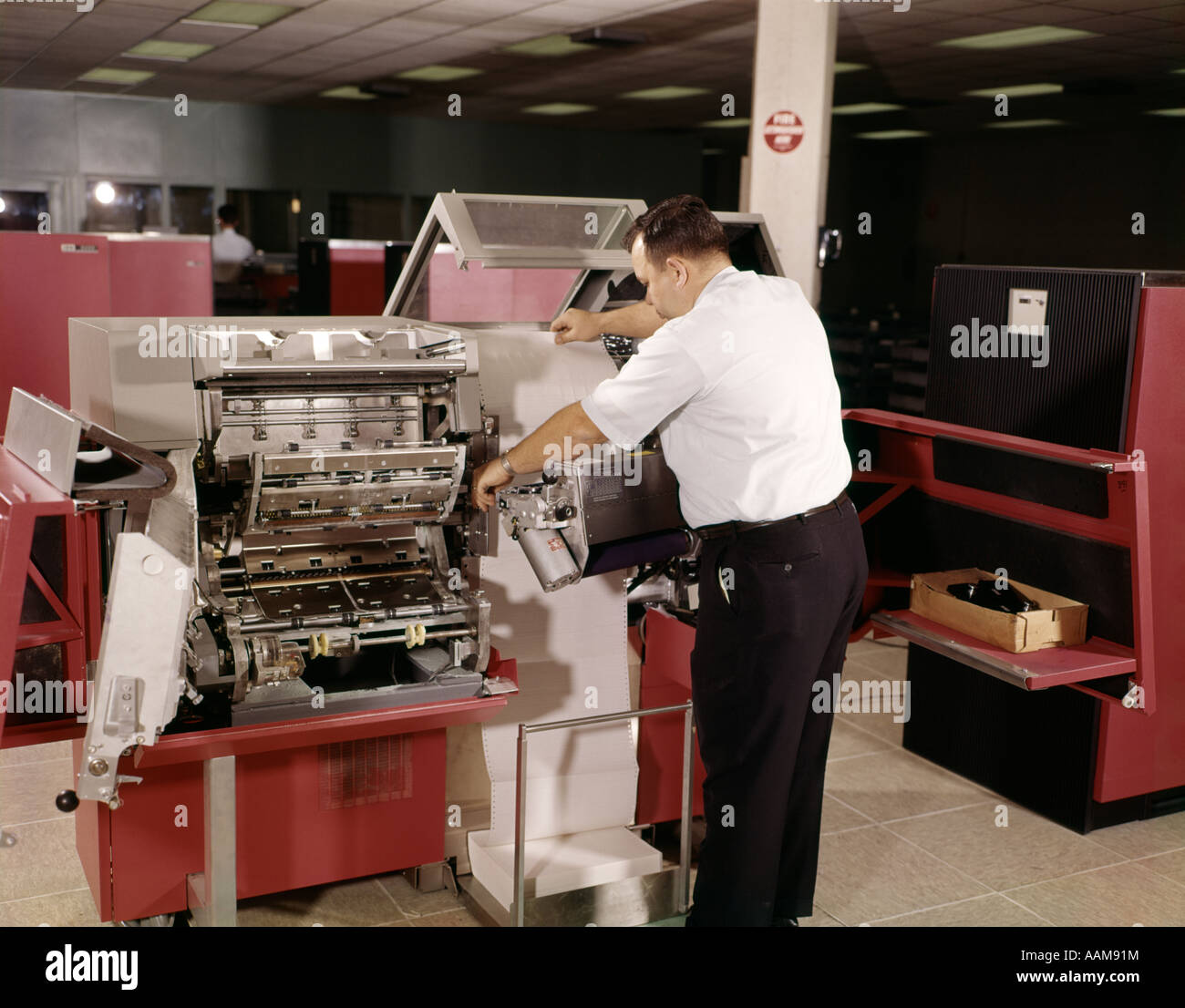 Anni Settanta uomo TECNICO DI COMPUTER LAVORA CON STAMPANTE DI COMPUTER Foto Stock