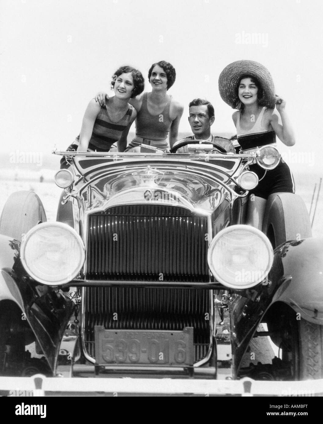 1920s 1930 uomo convertibile GUIDA TOURING CAR CON TRE DONNE IN COSTUMI DA BAGNO COME PASSEGGERI Foto Stock