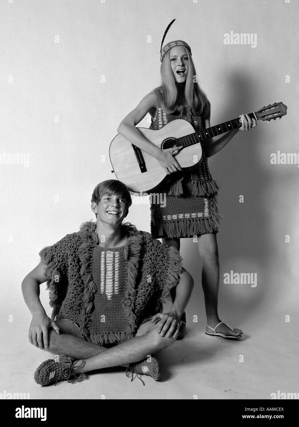 Anni sessanta anni settanta TEENAGE giovane vestito di uncinetto Vestiti  donna con archetto in piuma a suonare la chitarra uomo cantano Foto stock -  Alamy