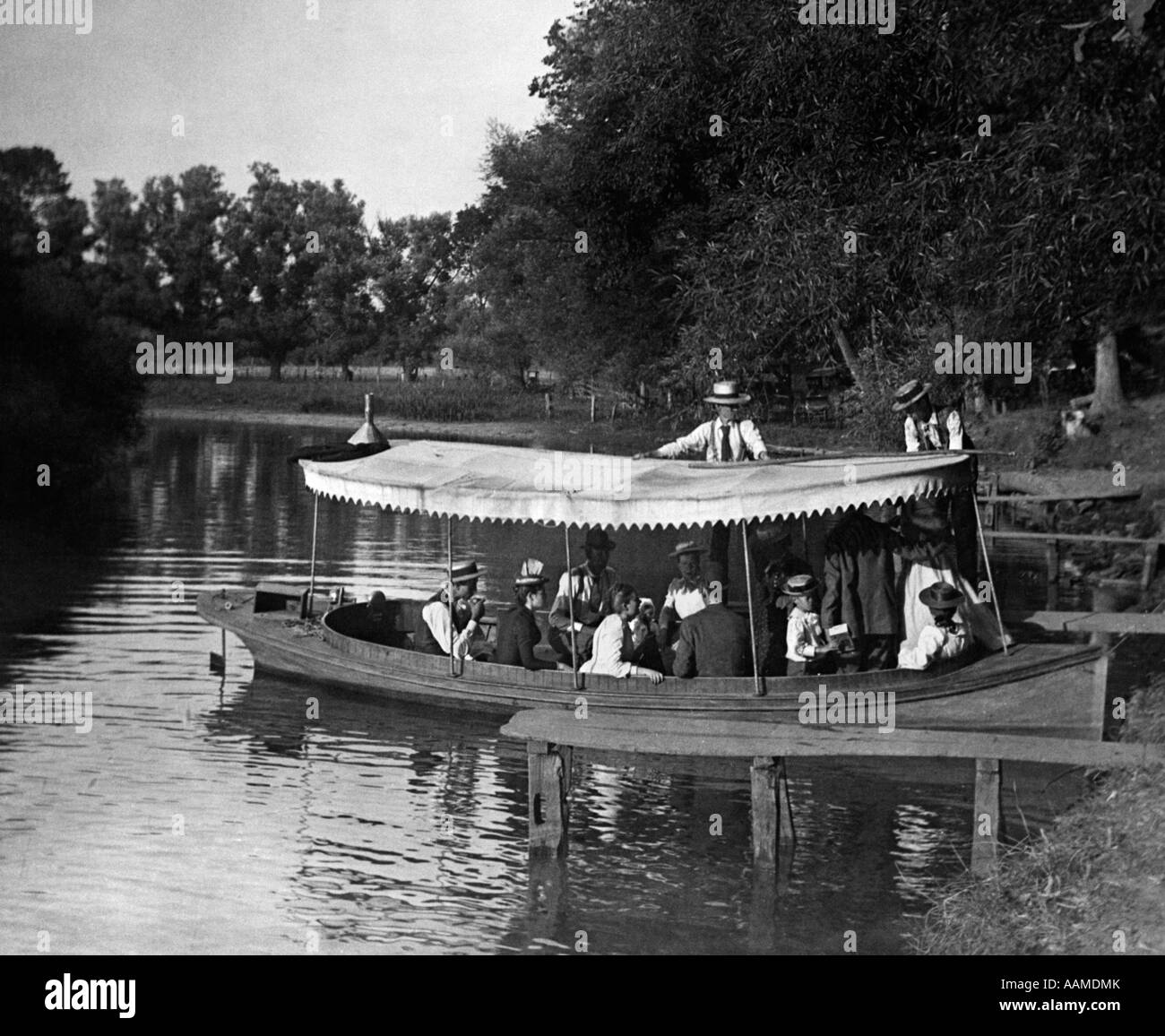 1890s 1900 svolta del secolo GRUPPO IN BARCA con la tettoia essendo spinto fuori in lago Foto Stock